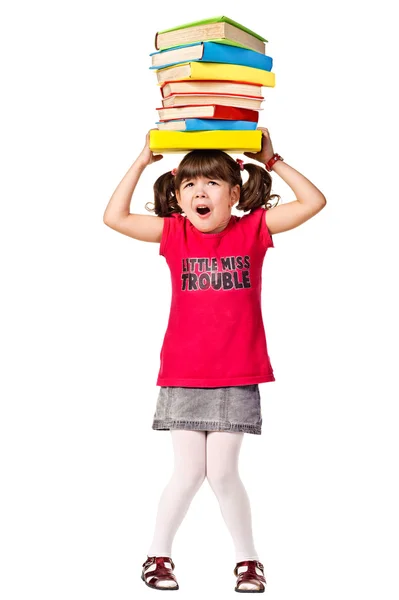Trochę uczennica ze stosem ciężkich książek na głowie — Zdjęcie stockowe