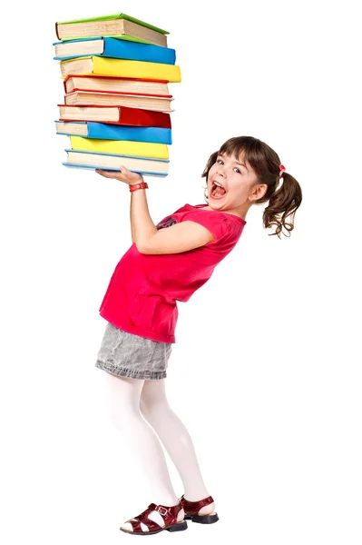 Happy little schoolgirl with a stack of heavy books — Stock Photo, Image
