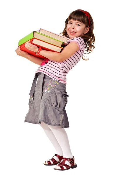 Gelukkig weinig schoolmeisje met een stapel van zware boeken — Stockfoto