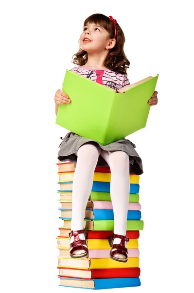 Menina sentada na pilha de livros . Imagens Royalty-Free