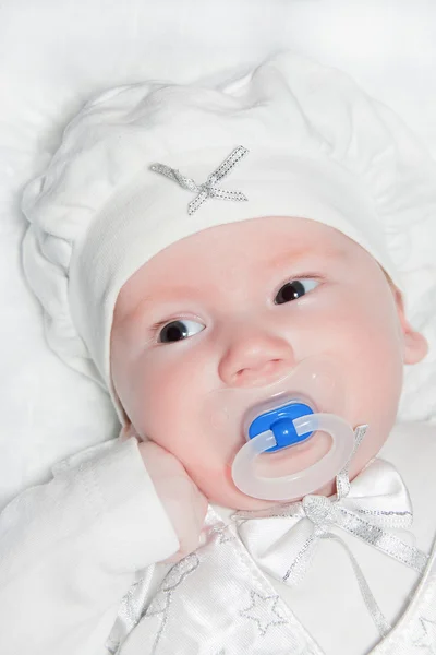 Младенец около двух месяцев в белом костюме — стоковое фото