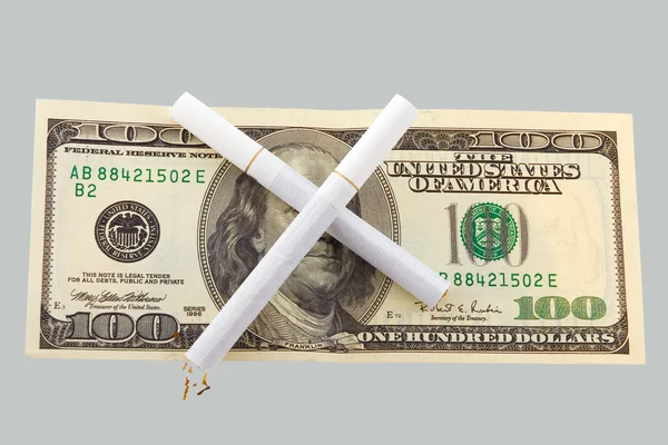Två cigaretter korsade över hundra dollar bill — Stockfoto