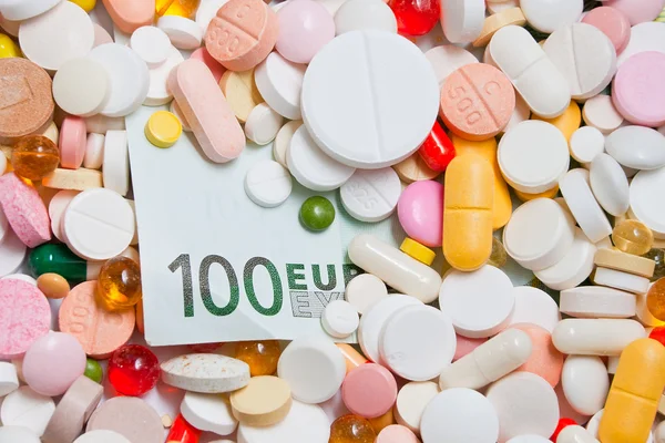 Un montón de pastillas y un billete de cien euros — Foto de Stock