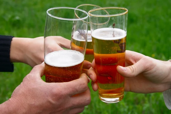 stock image Three glass with beer in men hands