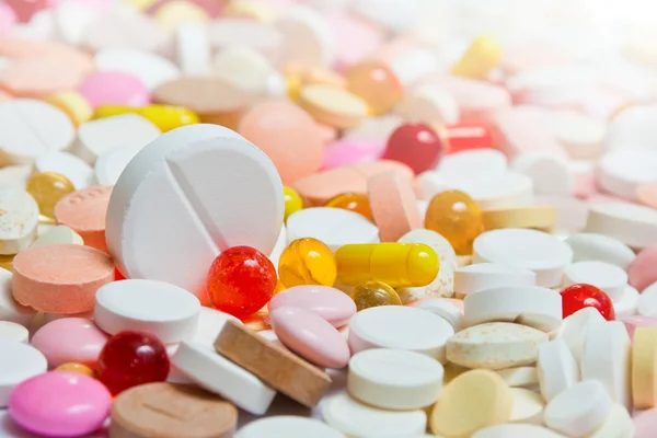 Wiele tabletek z wielkim wśród nich — Zdjęcie stockowe