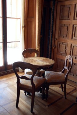 Interior with round table and three chairs clipart