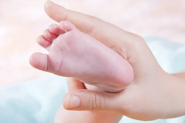 Dětské nohy v rukou ženy — Stock fotografie