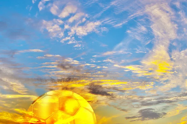 Prachtige veelkleurige zonsopgang met gouden voetbal bal. — Stockfoto