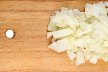 Chopped onions on a wooden board clipart