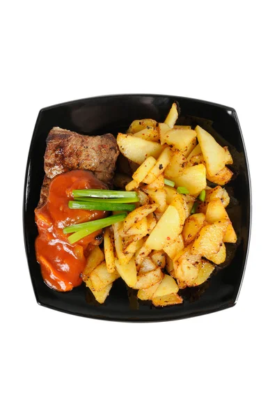 Grilované maso a smažené brambory na talíři — Stock fotografie