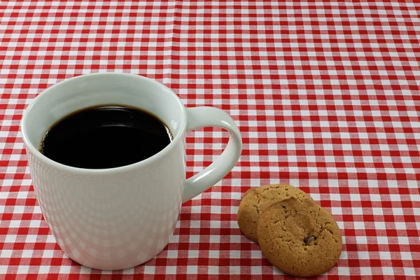 Kaffee und Kekse auf einer Tischdecke — Stockfoto