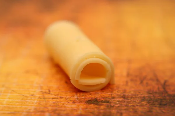 Roll of thin cheese piece — Stock Photo, Image