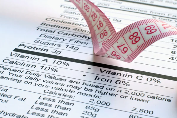 Nutrition facts and measure tape — Stock Photo, Image