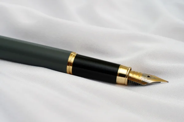Перьевая ручка на атласе — стоковое фото