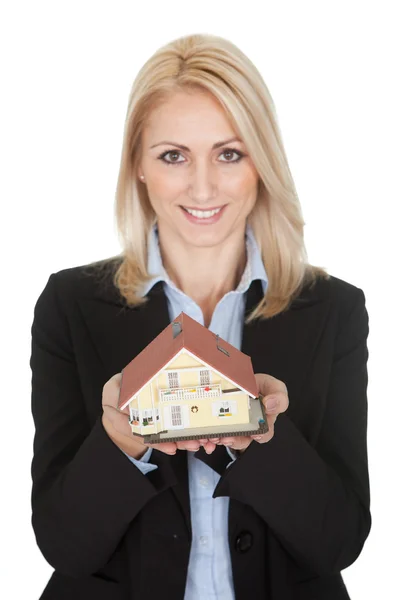 Businesswoman holding model of a house — Stock Photo, Image