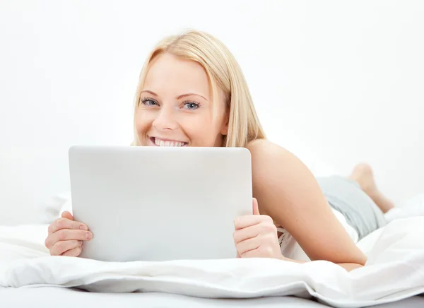 Jovem mulher bonita usando laptop na cama — Fotografia de Stock