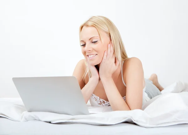Young beautiful woman using laptop in bed — Stock Photo, Image