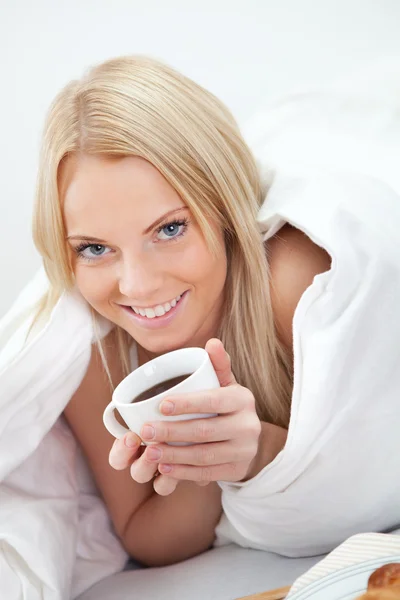 Красива жінка п'є каву в ліжку — стокове фото
