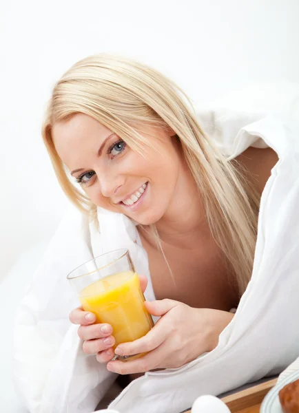 Mulher bonita beber suco na cama — Fotografia de Stock