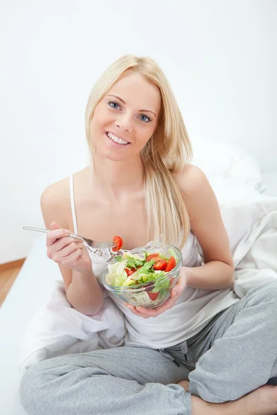 Vacker kvinna äta grön sallad — Stockfoto