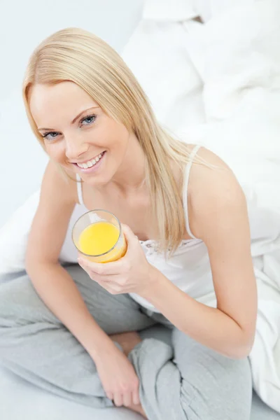 Mulher bonita beber suco na cama — Fotografia de Stock