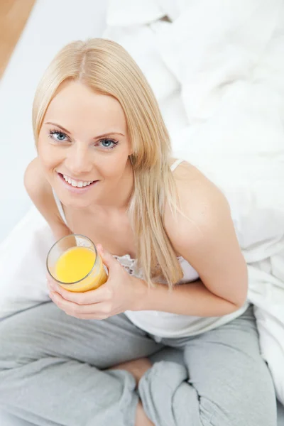 Mooie vrouw drinken sap in bed — Stockfoto