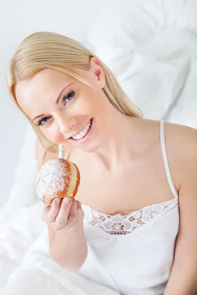 Beautiful woman eating tasty donut — Stock Photo, Image