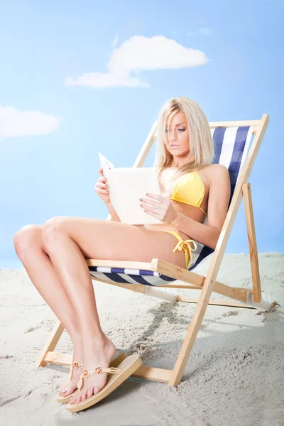Schöne junge Frau im Bikini liest ein Buch — Stockfoto