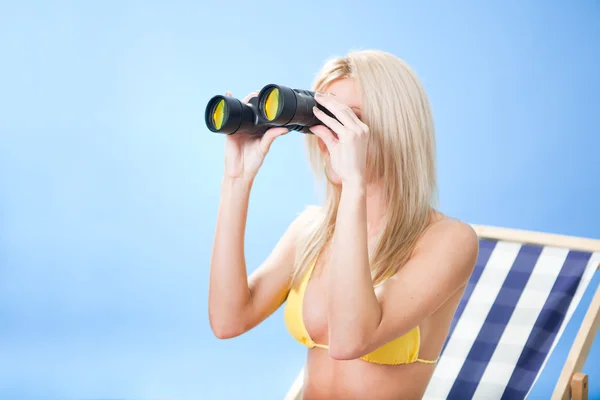 Young woman in bikini looking through binoculars — Stock Photo, Image