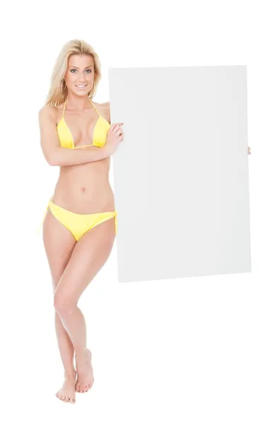 Frau im Bikini präsentiert leeres Brett — Stockfoto
