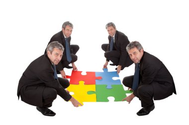 Senior business assembling a jigsaw puzzle clipart