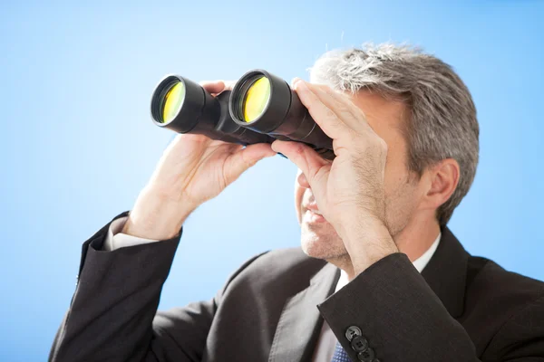Hombre de negocios mayor mirando a través de prismáticos —  Fotos de Stock