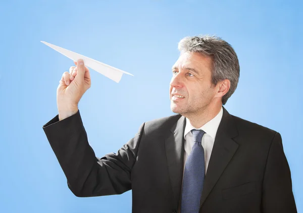 Hombre de negocios mayor lanzando un avión de papel — Foto de Stock