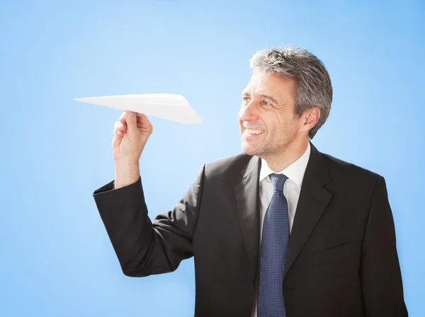 Uomo d'affari anziano che lancia un aereo di carta — Foto Stock
