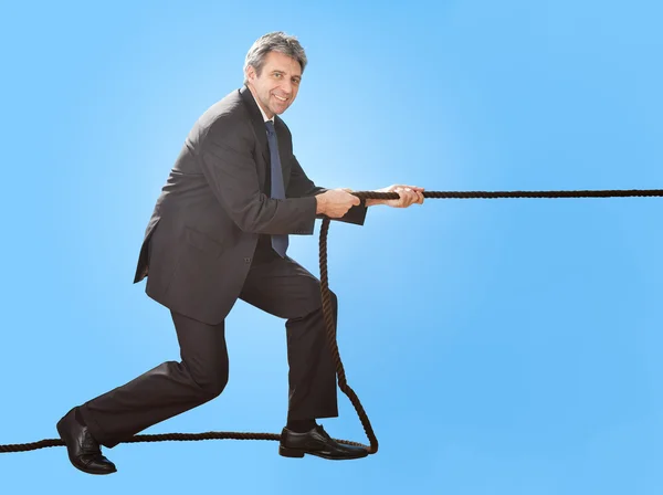 Empresários seniores puxando uma corda — Fotografia de Stock