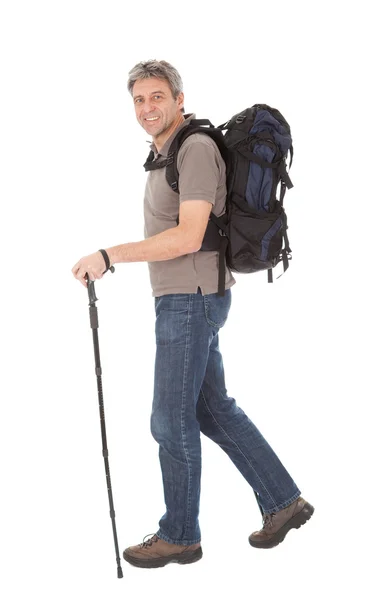 Старший чоловік з рюкзаком і пішохідними полюсами — стокове фото