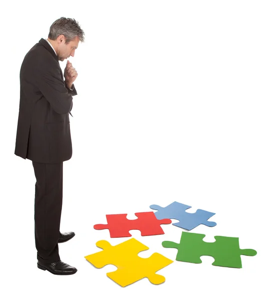Uomo d'affari anziano che assembla un puzzle — Foto Stock