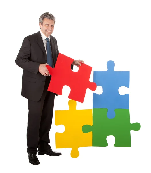 Senior zakenman samenstellen van een puzzel — Stockfoto