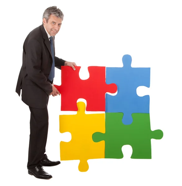 Empresário sênior montando um puzzle — Fotografia de Stock
