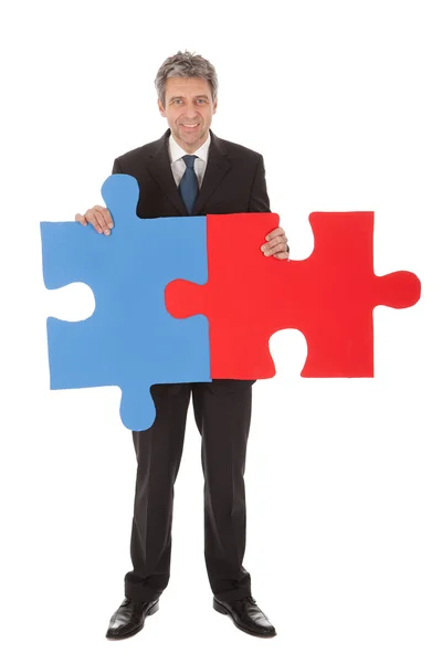 Homme d'affaires senior tenant un puzzle — Photo