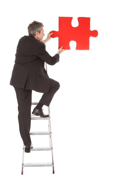 Senior businessman holding a jigsaw puzzle — Stock Photo, Image