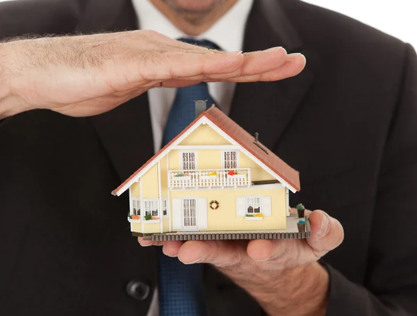 Affärsman hålla modell av ett hus i händerna — Stockfoto