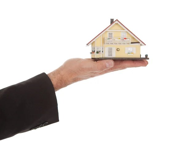 Empresário segurando modelo de uma casa em mãos — Fotografia de Stock