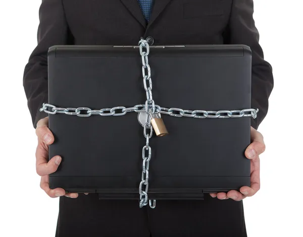 Бизнесмен держит ноутбук с цепью и замком — стоковое фото
