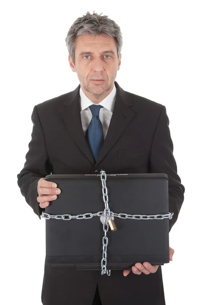Бизнесмен держит ноутбук с цепью и замком — стоковое фото