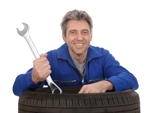 Automechanic leaning on car tires — Stock Photo, Image