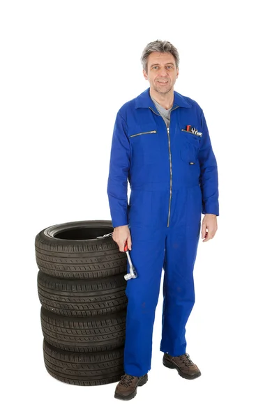 Automechanic stojący obok opon samochodowych — Zdjęcie stockowe