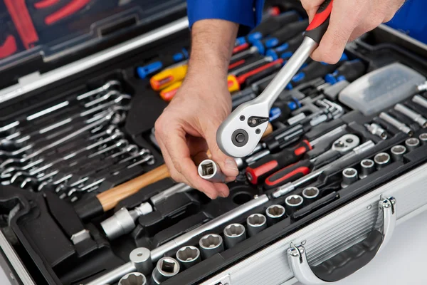 Retrato de un mecánico sacando una llave de la caja de herramientas —  Fotos de Stock