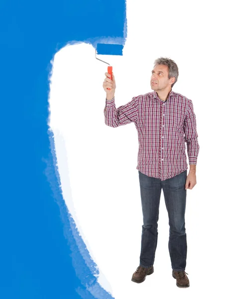 Senior adult schilderij muur in blauw — Stockfoto