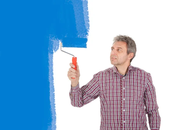 Senior adult painting wall in blue — Stock Photo, Image